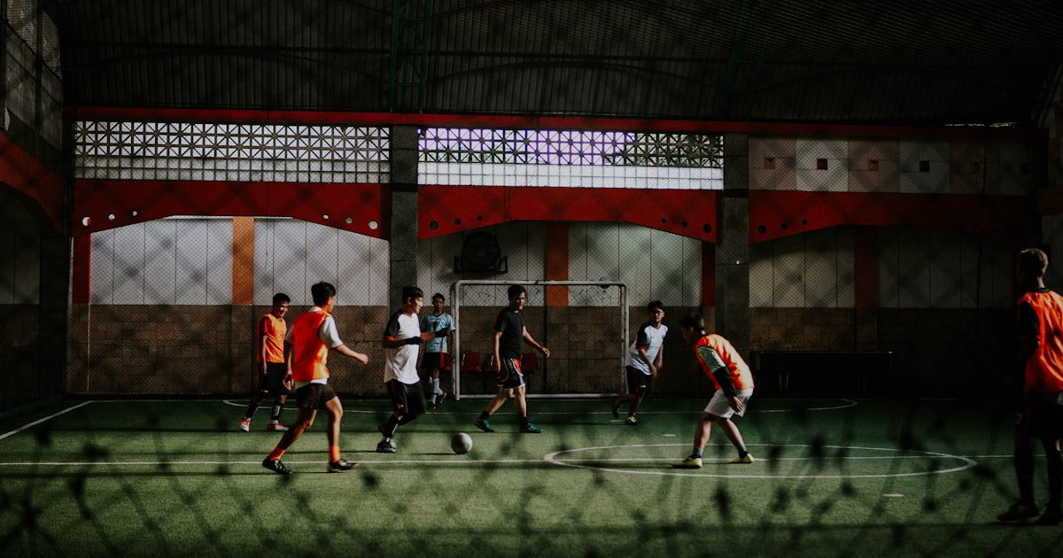 group of people playing soccer on field during daytime