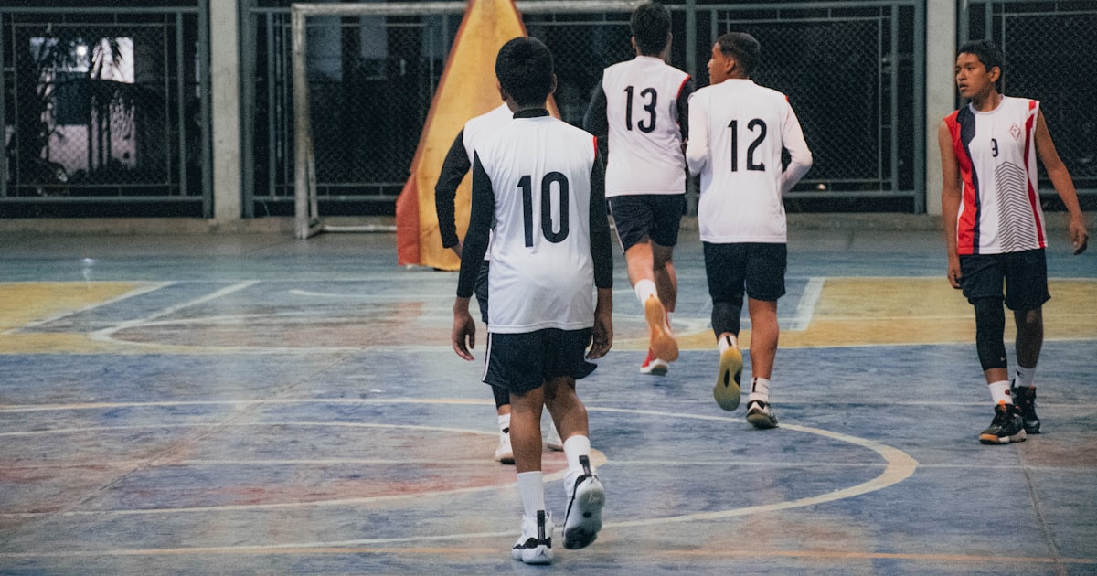 A group of young men playing a game of basketball