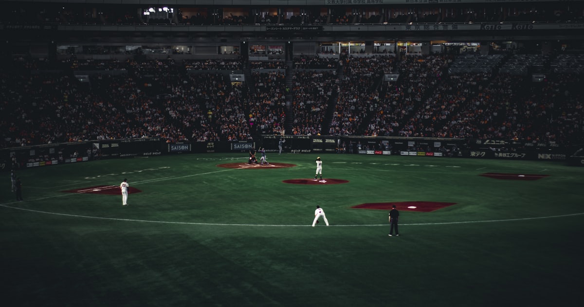 Baseball players on a field at night