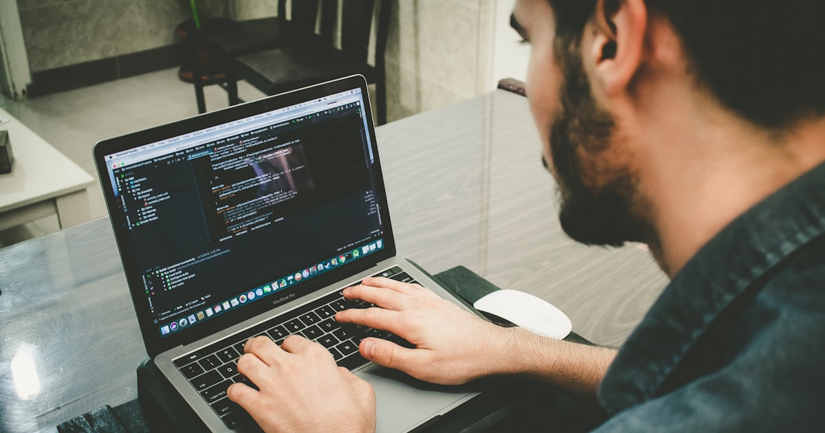 man programming using laptop