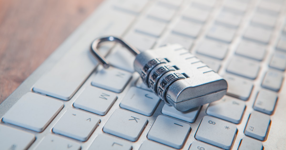A combination lock rests on a computer keyboard.