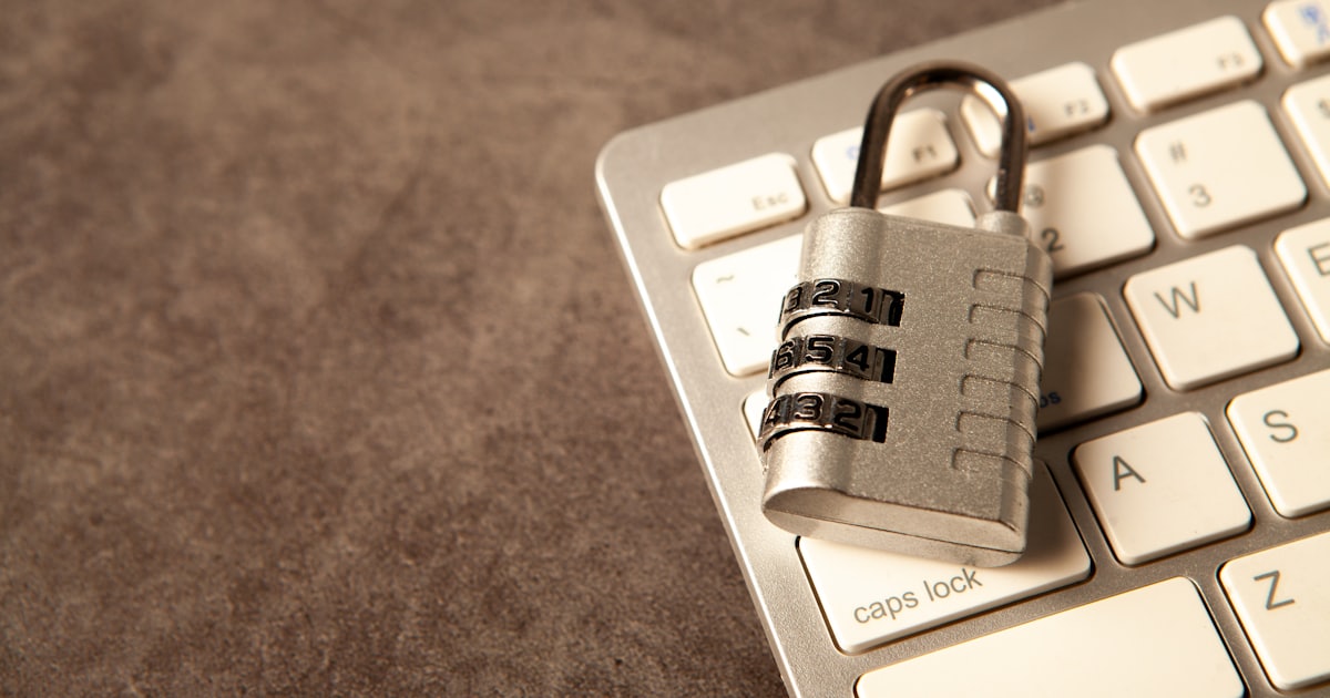 A padlock rests on a computer keyboard.