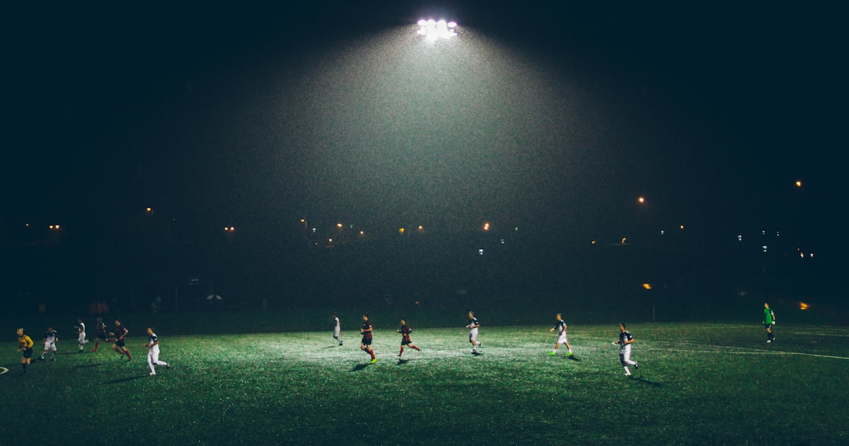 group of people playing soccer on soccer field